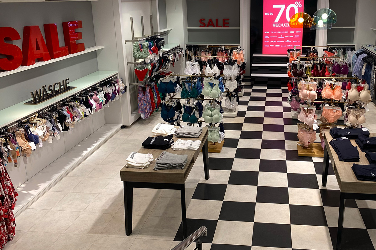 Das P&C Markenoutlet in Bremen mit Damen Unterwäsche mit einem SALE-Schild, Rabattangeboten bis zu 70% und einer Vielzahl von BHs und Slips auf Kleiderbügeln und Tischen.