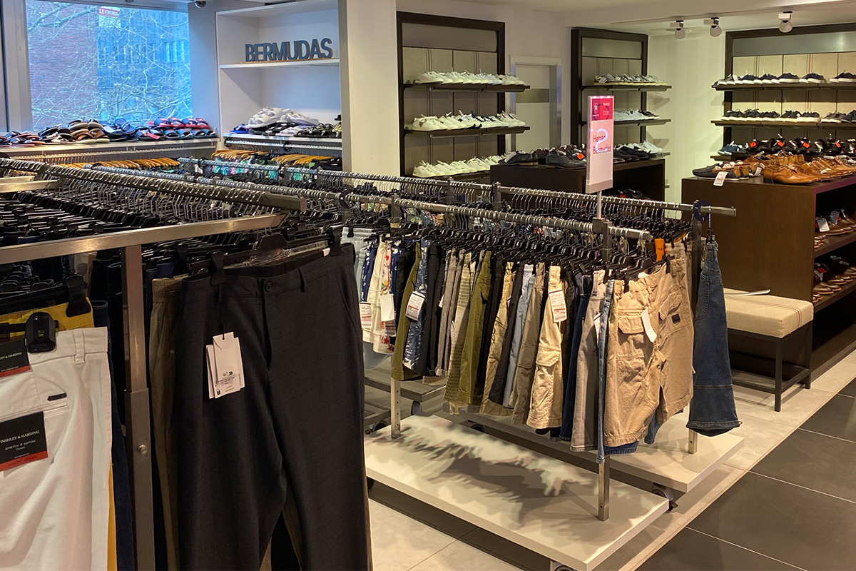 Das P&C Markenoutlet in Bremen mit Regalen voller Bermuda-Shorts und Schuhen für Herren.